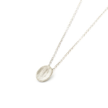 Minimalistische ovalen halsketting van Ines Bouwen Jewelry, handgemaakt in champagnegoud met een matte afwerking, weergegeven aan een fijne ketting.