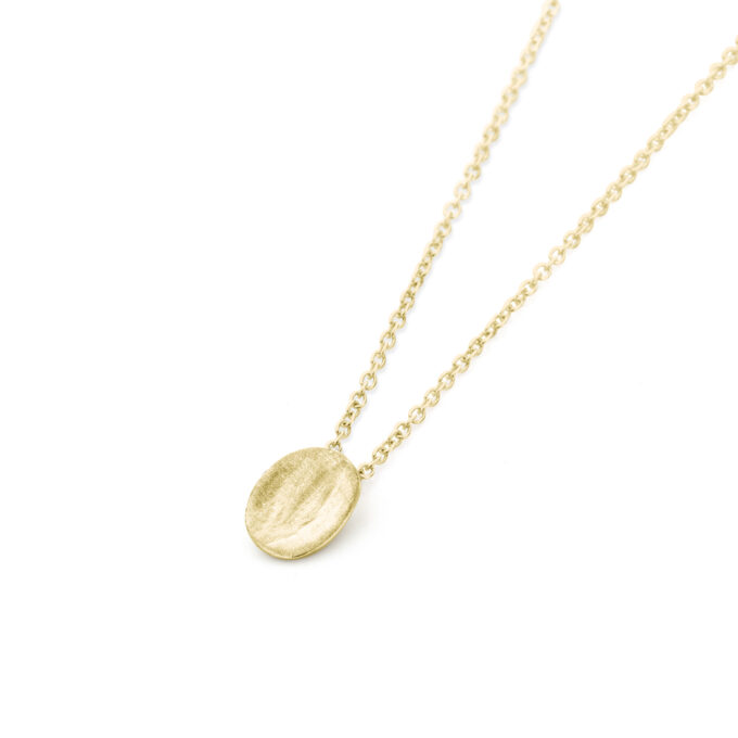 Minimalist yellow gold oval necklace by Ines Bouwen Jewelry, crafted in silver with a matte finish, displayed on a delicate chain.